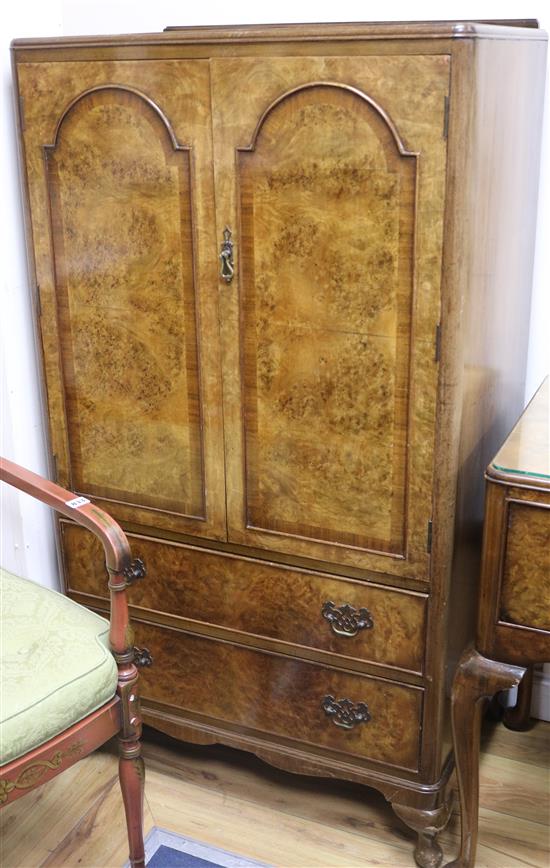 A small walnut gentlemans cupboard, fitted two doors over two small drawers W.75cm
